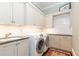 Functional laundry room with washer, dryer, and built-in storage at 4266 Paces Ferry Road Se, Atlanta, GA 30339