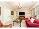 Comfortable living room featuring a decorative chandelier, entertainment center, and a cozy red sofa at 4266 Paces Ferry Road Se, Atlanta, GA 30339