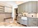 Stylish mudroom featuring custom cabinetry, a utility sink, and durable stone tile flooring at 4266 Paces Ferry Road Se, Atlanta, GA 30339