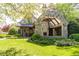 An outdoor stone fireplace and patio with dark wood ceiling beams and landscaped yard at 4266 Paces Ferry Road Se, Atlanta, GA 30339