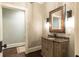 Stylish powder room with a decorative mirror and wood vanity at 4266 Paces Ferry Road Se, Atlanta, GA 30339