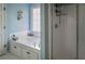 Bright bathroom with a built-in tub, storage cabinets, and a walk-in shower at 7522 Greens Mill Dr, Loganville, GA 30052
