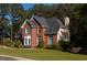 Beautiful brick home with lush green lawn, complemented by mature landscaping creating a welcoming curb appeal at 7522 Greens Mill Dr, Loganville, GA 30052