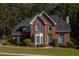 Charming two-story brick home featuring a manicured lawn and mature trees in a desirable neighborhood setting at 7522 Greens Mill Dr, Loganville, GA 30052