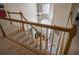 Carpeted staircase with white banisters, featuring natural light and an entryway view at 7522 Greens Mill Dr, Loganville, GA 30052