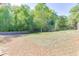 Expansive backyard featuring mature trees and a wooden fence, offering privacy and space for outdoor activities at 110 Legion Dr, Buford, GA 30518