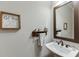 Half-bathroom with pedestal sink, stylish fixtures, and decorative wall art at 110 Legion Dr, Buford, GA 30518