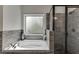Bathroom features a tile encased tub and glass enclosed shower at 110 Legion Dr, Buford, GA 30518