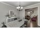 Dining room adjacent to the living room, with white trim and a modern chandelier at 110 Legion Dr, Buford, GA 30518