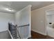 Upstairs hallway with hardwood floors and a dark metal railing at 110 Legion Dr, Buford, GA 30518