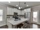 Well-lit kitchen featuring white cabinets, stainless steel appliances, and a granite countertop island with barstool seating at 110 Legion Dr, Buford, GA 30518