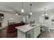 Spacious open-concept living area with modern kitchen, dining space, and a stone fireplace at 110 Legion Dr, Buford, GA 30518
