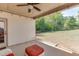 Cozy covered patio with seating area overlooking spacious backyard with mature trees and a wooden fence at 110 Legion Dr, Buford, GA 30518