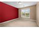 Bright bedroom featuring beige carpet, and one red accent wall. Large window provides ample natural light at 203 Setters Rdg, Canton, GA 30115