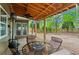 Inviting covered patio with fan, outdoor dining furniture, and view of backyard at 203 Setters Rdg, Canton, GA 30115