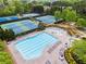 Aerial view of a community pool and several tennis courts surrounded by mature trees and landscaping at 203 Setters Rdg, Canton, GA 30115