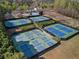 Aerial view of several fenced tennis courts within a community surrounded by trees and shrubbery at 203 Setters Rdg, Canton, GA 30115
