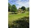 A view of the front yard with mature trees and neatly arranged landscaping at 2126 Monterey Dr, Snellville, GA 30039