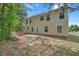 View of the house's backyard featuring green grass, a small patio, and trees around the perimeter at 2640 Thunder Basin Way, Douglasville, GA 30135