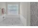 Large soaking tub next to a shower with a patterned curtain at 2640 Thunder Basin Way, Douglasville, GA 30135
