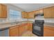 Bright kitchen showcasing wood cabinetry, black appliances, and neutral countertops, perfect for culinary enthusiasts at 2640 Thunder Basin Way, Douglasville, GA 30135