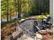 Backyard firepit area with stone steps, landscaping, and lake views at 3290 Dunlop Ne Ct, Atlanta, GA 30319