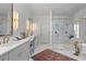 Elegant bathroom featuring double vanities, gold fixtures, and a luxurious marble shower with a glass enclosure at 3290 Dunlop Ne Ct, Atlanta, GA 30319