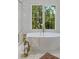 Close up on a white free standing tub and gold fixtures in a bathroom with a window at 3290 Dunlop Ne Ct, Atlanta, GA 30319