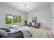 Spacious bedroom with a large window, light wood floors, and an inviting sitting area with two chairs at 3290 Dunlop Ne Ct, Atlanta, GA 30319