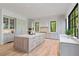 A gourmet kitchen with a large island, wood floors, black trimmed windows, and stainless steel appliances at 3290 Dunlop Ne Ct, Atlanta, GA 30319