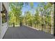 Expansive outdoor patio with sleek railings showcasing the property's serene, wooded backdrop, and elegant lighting at 3290 Dunlop Ne Ct, Atlanta, GA 30319