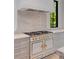 A luxury oven range with a stone backsplash and custom vent hood at 3290 Dunlop Ne Ct, Atlanta, GA 30319