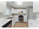 Well-lit kitchen with stainless steel appliances, white cabinets, modern countertops, and new luxury vinyl plank flooring at 2154 Windstream Sw Way, Marietta, GA 30060
