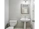 Half-bath featuring pedestal sink, toilet and framed mirror at 2461 Peregrine Trl, Suwanee, GA 30024