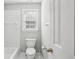 Bathroom featuring tiled shower-tub, toilet and bright window at 2461 Peregrine Trl, Suwanee, GA 30024