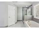 Bright bathroom with a large tub and a glass-enclosed shower near a white door at 2461 Peregrine Trl, Suwanee, GA 30024