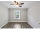 Light filled bedroom with wood-look floors, ceiling fan and neutral paint at 2461 Peregrine Trl, Suwanee, GA 30024