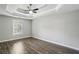Light-filled primary bedroom featuring a trey ceiling, ceiling fan, and hardwood floors at 2461 Peregrine Trl, Suwanee, GA 30024