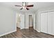 Neutral bedroom featuring hardwood floors, a ceiling fan, closet, and doors at 2461 Peregrine Trl, Suwanee, GA 30024