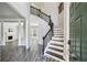 Inviting foyer with a staircase, dark wood floors and modern lighting fixtures at 2461 Peregrine Trl, Suwanee, GA 30024