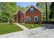 View of the beautiful brick home with a large front lawn, walkway, and lush greenery at 2461 Peregrine Trl, Suwanee, GA 30024
