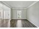 Bright living room with wood flooring, crown molding, and a large window at 2461 Peregrine Trl, Suwanee, GA 30024