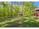 Expansive backyard featuring lush green lawn, mature trees, and a charming shed, ideal for outdoor activities and relaxation at 363 Ridge Run Dr, Hiram, GA 30141