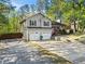 View of the beautiful gray house with a two-car garage, inviting front porch and driveway lined with trees at 363 Ridge Run Dr, Hiram, GA 30141
