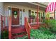 Inviting front porch with a decorative wreath, American flag, and potted plants that create a welcoming entrance at 363 Ridge Run Dr, Hiram, GA 30141
