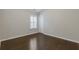 This bedroom has a hardwood floor, white trim and door, and a window with white shutters at 3715 Lexington Rd, Tucker, GA 30084