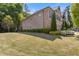 View of home's expansive lawn, mature trees, and neutral siding with brick accents at 3715 Lexington Rd, Tucker, GA 30084