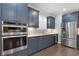 Modern kitchen with stainless steel appliances, blue cabinets, and granite countertops at 3715 Lexington Rd, Tucker, GA 30084