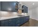 Stylish kitchen featuring stainless steel hood, gas range, white backsplash, and blue cabinets at 3715 Lexington Rd, Tucker, GA 30084