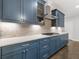 A well-equipped kitchen showcases stainless steel appliances and sleek, blue cabinetry at 3715 Lexington Rd, Tucker, GA 30084